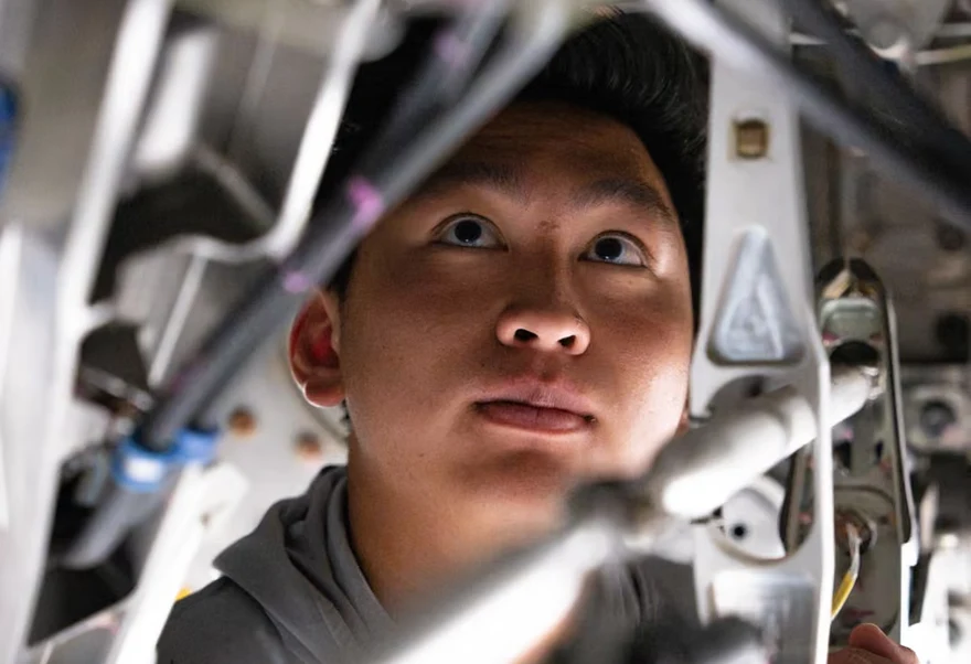 A Boom engineer looking up through the hardware he is working on