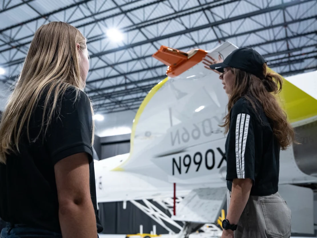 Two Boom team members beside XB-1 in the hangar